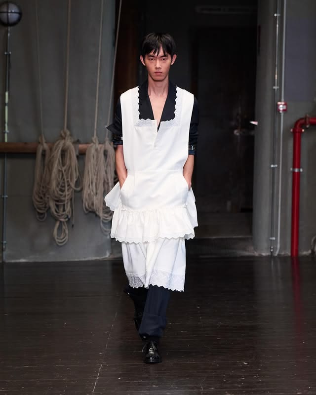 Look 37 HEWEI An apron, in evening cotton with Broderie Anglaise panelling, worn over a single-breasted backless jacket with apron tie in Venetian wool.